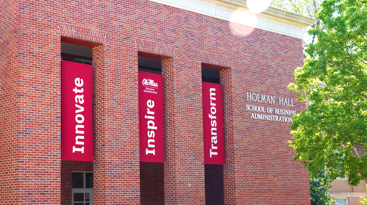 Front of Holman Hall with banners saying: Innovate, Inspire, and Transform.