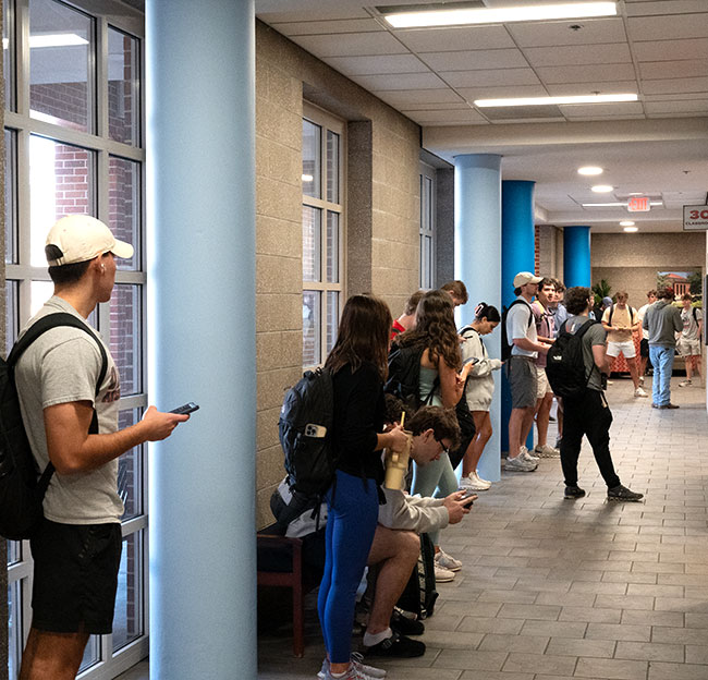 Students waiting outside a classroom in the ground floor of Holman Hall.