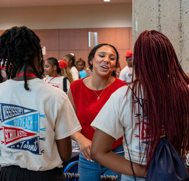 Abby Yuan tabling during the MOST conference in the Student Union while engaging with two perspective students.