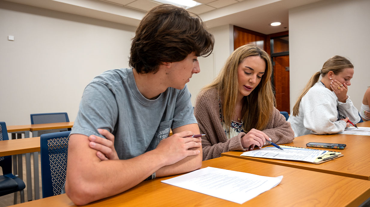 Addison House (right), advising an incoming male student (left), and two other female students in the background.