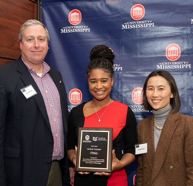 Clay Dibrell and Tong Meng presenting an award to a student.