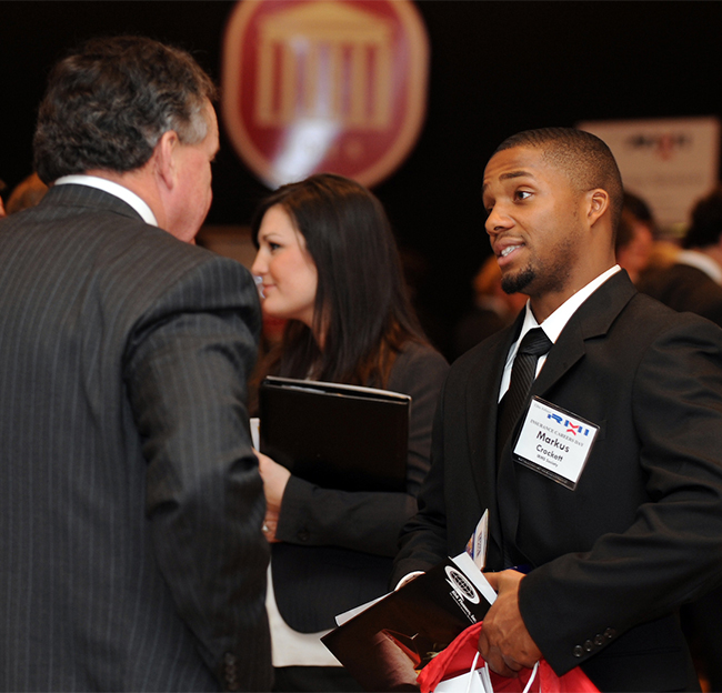 Two business professionals speaking with each other during a conference.