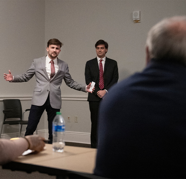 Two male students presenting during an MBA course.