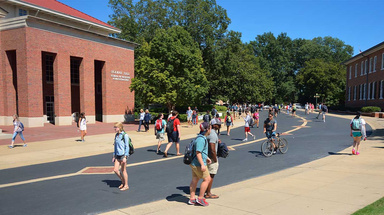 Photo of students walking outside Holman Hall and Business Row. 