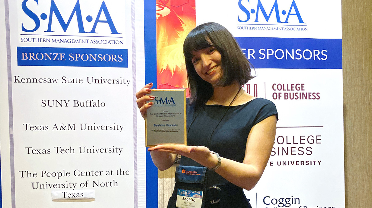 Photo of Beatrisa Pucalev holding an award.