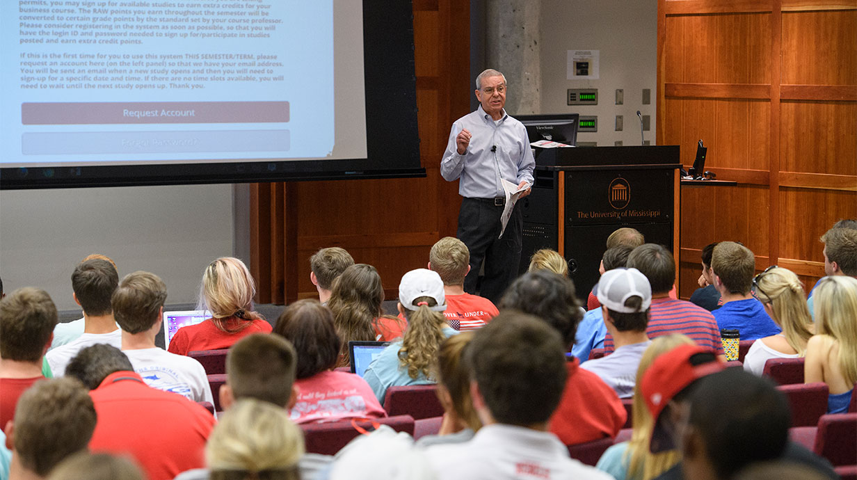 Sam Cousley, instructional associate professor of marketing, lectures during his Marketing Principles class in Holman Hall Auditorium. Photo credit: Thomas Graning