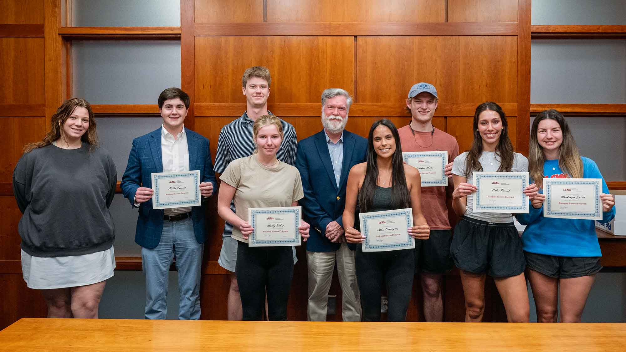 Dean Cyree with a group of students who completed the Business Success Program showcasing their certificates.
