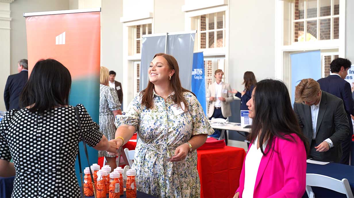 Photo of two female employers during a RMI career fair interacting with a faculty member.