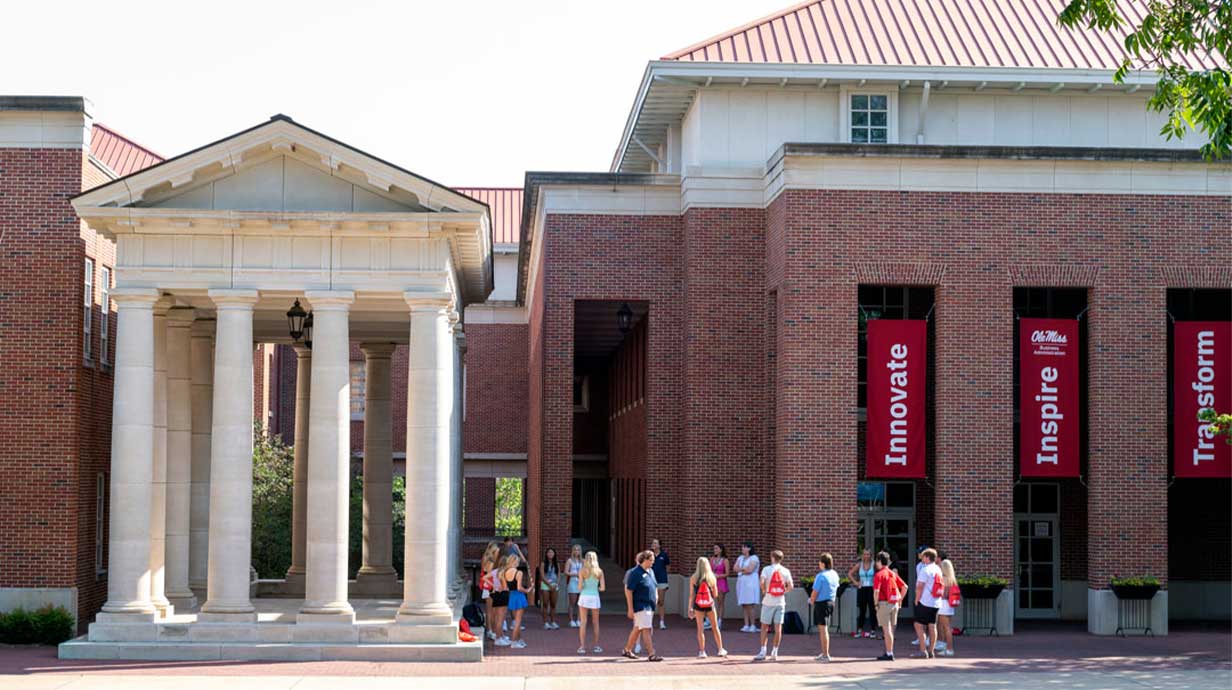A group of students outside the Holman Hall on the Oxford, MS campus.