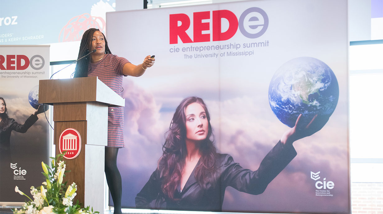 Photo of a female guest speaker during a previous REDe event.