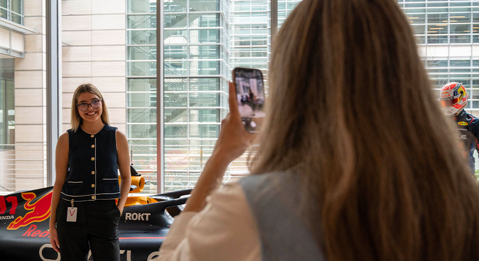 Students take photos in front of a Formula 1 race car at ExxonMobil HQ in Houston, Texas.
