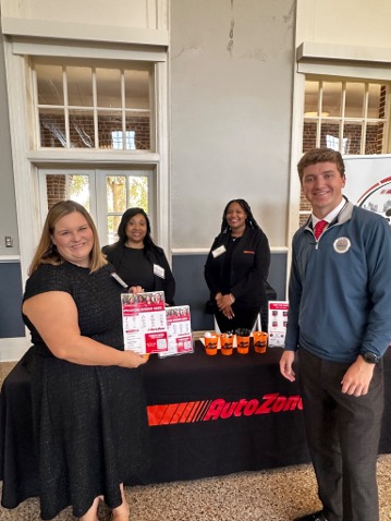Marshall Farnham (right), an Ole Miss junior and president of the Finance Club, talks with AutoZone representatives to build connections and explore opportunities.