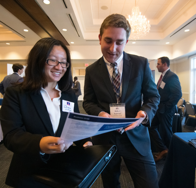 A female and male in business attire during a convention.