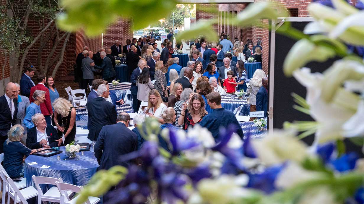 A large crowd of people for the Hall of Fame event in the courtyard of Holman Hall.
