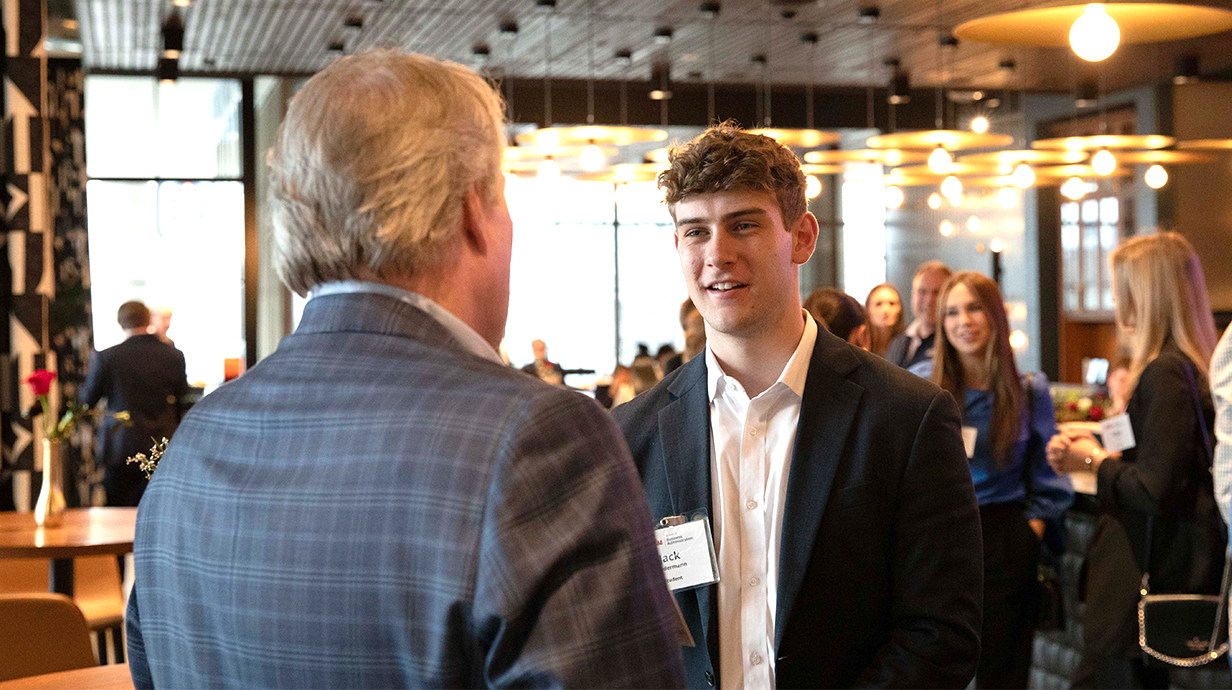 A student having a conversation with an potential employer during an event.