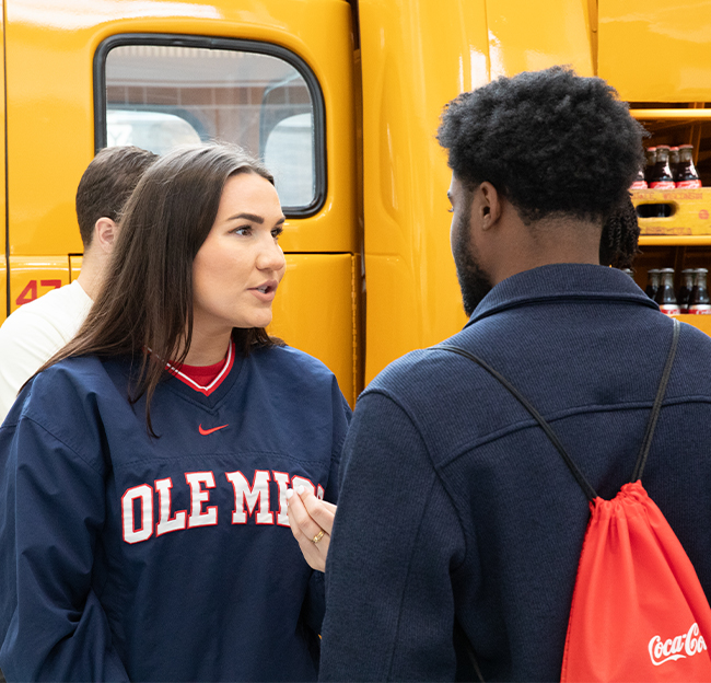 A Coca-Cola employee, Ole Miss Alumna, speaking with a business student at the Coca-Cola Company HQ.