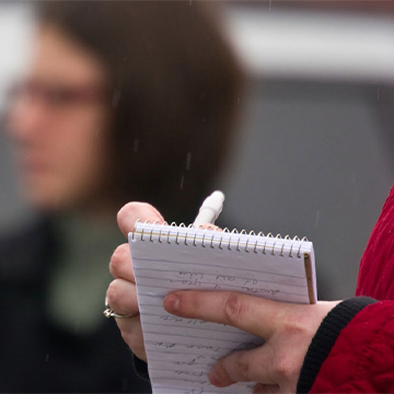 A person writing on a notepad.