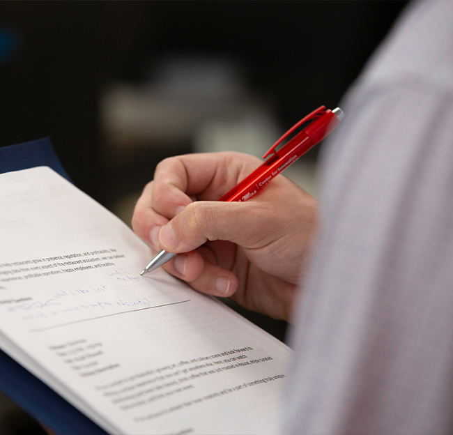 A close up photo a person taking down notes on a piece of paper.