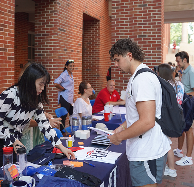 A student visiting a table during the Open for Business event in 2023.