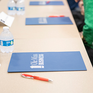 A table with an Ole Miss Business folder on top of it. 