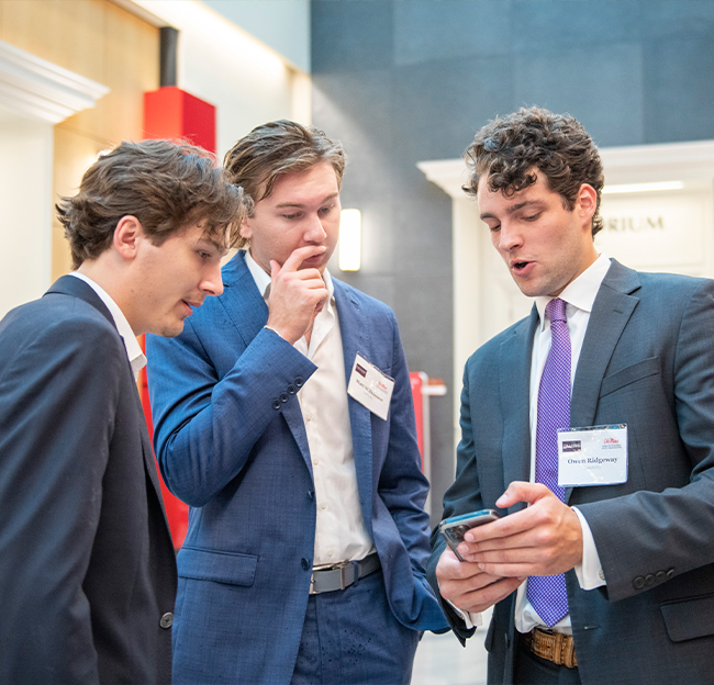 Three students looking at something amazing on a phone.