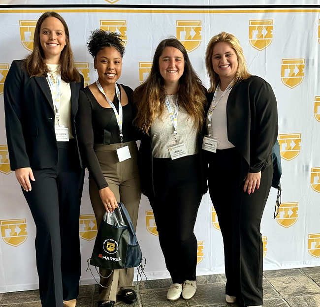 Group photo of four female members of Gamma Iota Sigma.