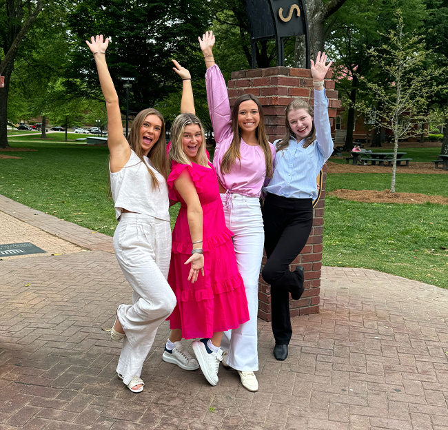 Three female students in front of the walk of champions cropped.