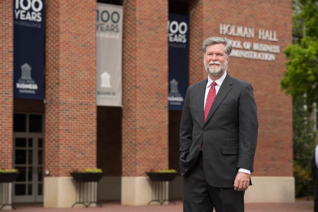 Dean of Business School Dr. Ken Cyree standing in front of Holman Hall in suit